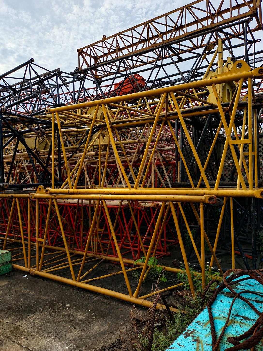 Kobelco 55 ton crane boom sections stacked in an industrial yard